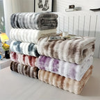 Soft faux rabbit fur throw blanket draped over a bed